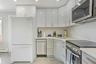a kitchen with white cabinets and a white refrigerator at Cozy Lakefront House with a private dock and lake in Hopatcong