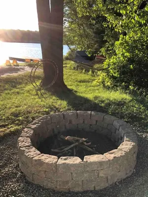 a brick fire pit in front of a tree at Swept Away in Arrowhead Lake in Arrowhead Lake