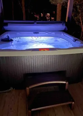 a jacuzzi tub with a bench in front of it at Swept Away in Arrowhead Lake in Arrowhead Lake