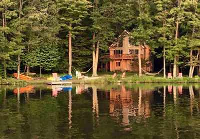 a house sitting on the shore of a lake at Swept Away in Arrowhead Lake in Arrowhead Lake