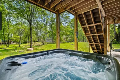 a jacuzzi tub in the backyard of a house at Hot Tub and Community Beach Albrightsville Home! in Albrightsville
