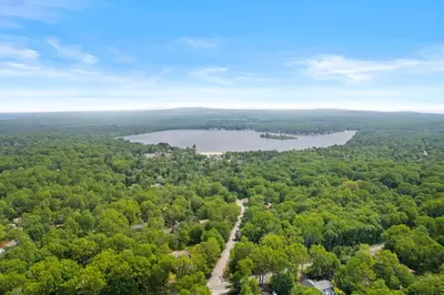 an aerial view of a lake in the woods at Hot Tub and Community Beach Albrightsville Home! in Albrightsville