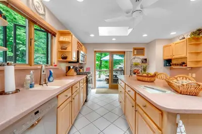 a large kitchen with wooden cabinets and a large island at Lakefront at the Hideout in Lake Ariel