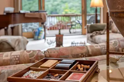 a living room with a couch and a table and a piano at Lakefront at the Hideout in Lake Ariel