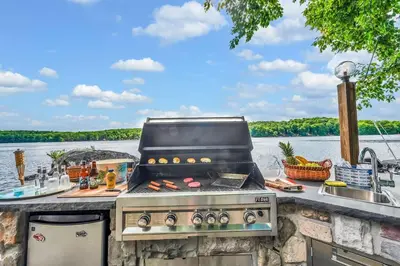 a grill on a counter next to a body of water at Lakefront at the Hideout in Lake Ariel