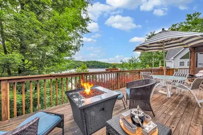 a patio with a fire pit on a deck at Lakefront at the Hideout in Lake Ariel