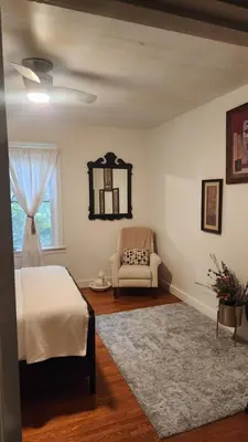 a bedroom with a bed and a chair and a window at Entire rear squad-bay in Carlisle