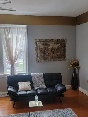a living room with a black couch and a window at Entire rear squad-bay in Carlisle