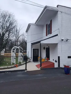 a white house with a porch with a couch in it at Entire rear squad-bay in Carlisle