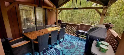 a screened in porch with a wooden table and chairs at Getaway at the Hideout in Lake Ariel