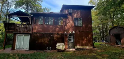 a house that is sitting in the grass at Getaway at the Hideout in Lake Ariel