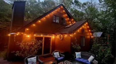 a small house with lights on the side of it at Getaway at the Hideout in Lake Ariel