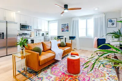 a living room with a couch and a kitchen at Elegant Urban Escape - 2 Bedrooms, 1 king Bed and 1 Queen Bed, Gated Private Entrance and Parking in Philadelphia