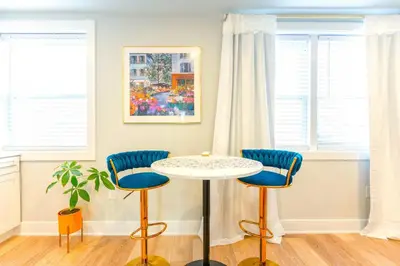 a table and two chairs in a room with windows at Elegant Urban Escape - 2 Bedrooms, 1 king Bed and 1 Queen Bed, Gated Private Entrance and Parking in Philadelphia