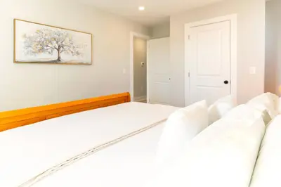 a bedroom with a bed and two white couches at Elegant Urban Escape - 2 Bedrooms, 1 king Bed and 1 Queen Bed, Gated Private Entrance and Parking in Philadelphia