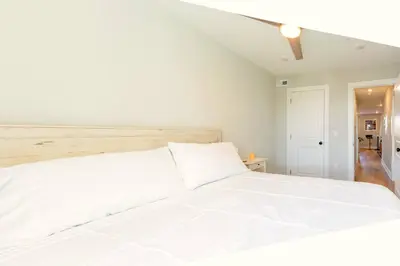 a white bedroom with a large white bed at Elegant Urban Escape - 2 Bedrooms, 1 king Bed and 1 Queen Bed, Gated Private Entrance and Parking in Philadelphia