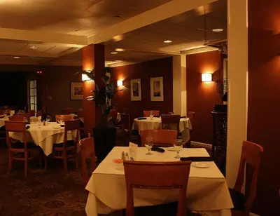 a restaurant with tables and chairs with white table cloth at Macaluso's at the Lantern Lodge in Jim Thorpe