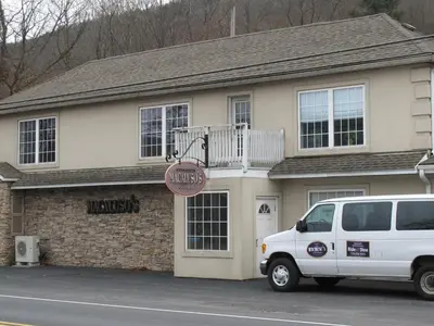 a white van parked in front of a building at Macaluso's at the Lantern Lodge in Jim Thorpe