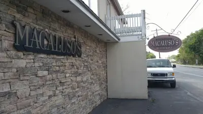 a car parked outside of a building with a sign at Macaluso's at the Lantern Lodge in Jim Thorpe