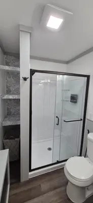 a bathroom with a toilet and a glass shower at Charming 3-BR Riverside country farmhouse Retreat Huge Yard & Fire Pit