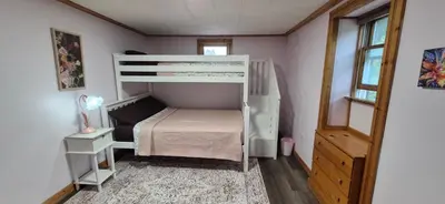 a small bedroom with a bunk bed and a ladder at Charming 3-BR Riverside country farmhouse Retreat Huge Yard & Fire Pit