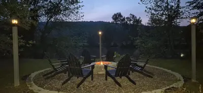 a group of chairs around a fire pit at night at Charming 3-BR Riverside country farmhouse Retreat Huge Yard & Fire Pit