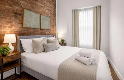 a bedroom with a large bed with towels on it at Stylish Retreat in Prime West Village Spot in New York