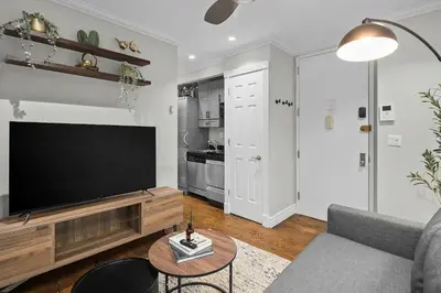 a living room with a large flat screen tv at Trendy East Village Escape in New York