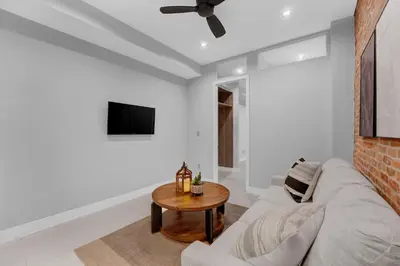 a living room with a couch and a table at Modern West Village 1BR Garden steps to subway in New York