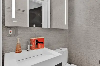 a bathroom with a white sink with a book on it at Modern West Village 1BR Garden steps to subway in New York