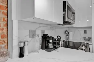 a kitchen with a coffee maker on a counter at Modern West Village 1BR Garden steps to subway in New York
