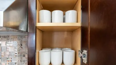a cupboard with a bunch of white cups in it at Luxury Retreat Walk 2 PATH NYC in Mins Parking in Jersey City