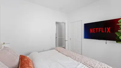 a white room with a tv on a wall at Luxury Retreat Walk 2 PATH NYC in Mins Parking in Jersey City
