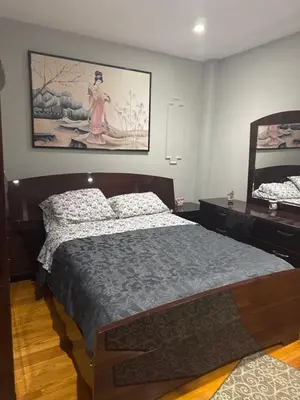 a bedroom with a bed and a painting on the wall at Cozy in Guttenberg