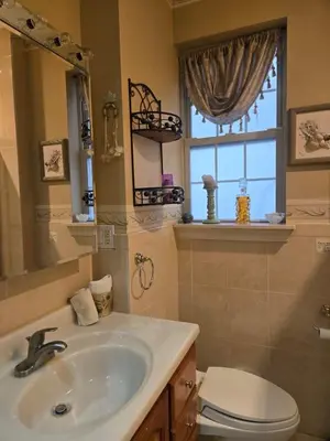 a bathroom with a sink and a toilet and a window at Cozy in Guttenberg