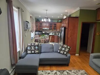 a living room with a couch and a kitchen at Cozy in Guttenberg