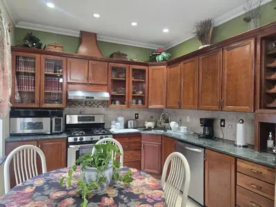a kitchen with wooden cabinets and a table with chairs at Cozy in Guttenberg