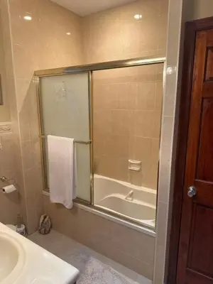a bathroom with a shower and a tub and a sink at Cozy in Guttenberg