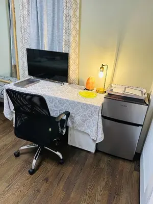 a room with a desk with a chair and a table with a computer at The Trenton Two 2BR Peaceful Oasis with Patio - Shared Home in Trenton