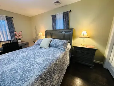 a bedroom with a bed with a blue comforter at The Trenton Two 2BR Peaceful Oasis with Patio - Shared Home in Trenton