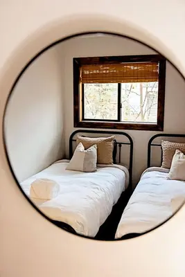 two beds in a room with a mirror at Luxurious Cabin by Lakes & Ski in Lake Ariel