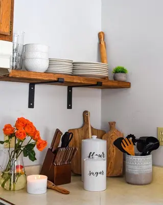 a kitchen counter with plates and utensils on a shelf at Luxurious Cabin by Lakes & Ski in Lake Ariel