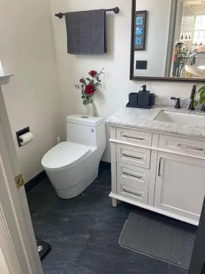 a white bathroom with a toilet and a sink at Aum Quite Heaven Stay in Monroe Township