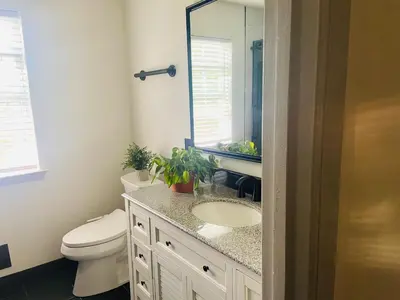 a bathroom with a toilet and a sink and a mirror at Aum Quite Heaven Stay in Monroe Township