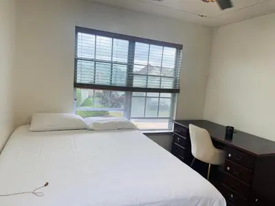 a bedroom with a bed and a desk and a window at Aum Quite Heaven Stay in Monroe Township