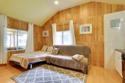 a bedroom with a bed and a couch and a window at Screened Porch and Fire Pit Cabin Near Bethel Woods in Mongaup Valley