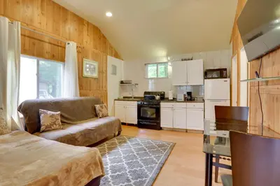 a living room with a couch and a kitchen at Screened Porch and Fire Pit Cabin Near Bethel Woods in Mongaup Valley