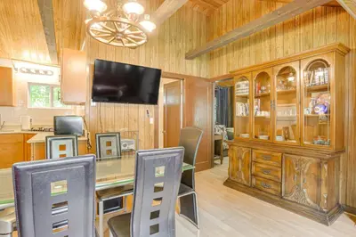 a dining room with a table with chairs and a television at Community Perks Mongaup Valley Cabin with Grill! in Mongaup Valley