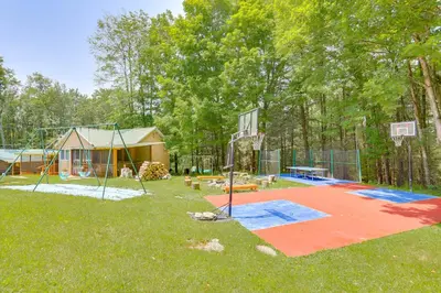 a backyard with a basketball hoop and a house at 5 Mi to Swinging Bridge Reservoir Cabin with Porch! in Mongaup Valley