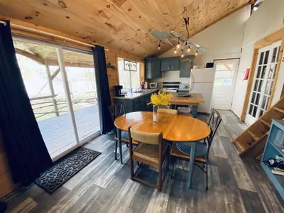 a kitchen and dining room with a wooden table and chairs at UndertheWillows by Towanda Sayre in Ulster